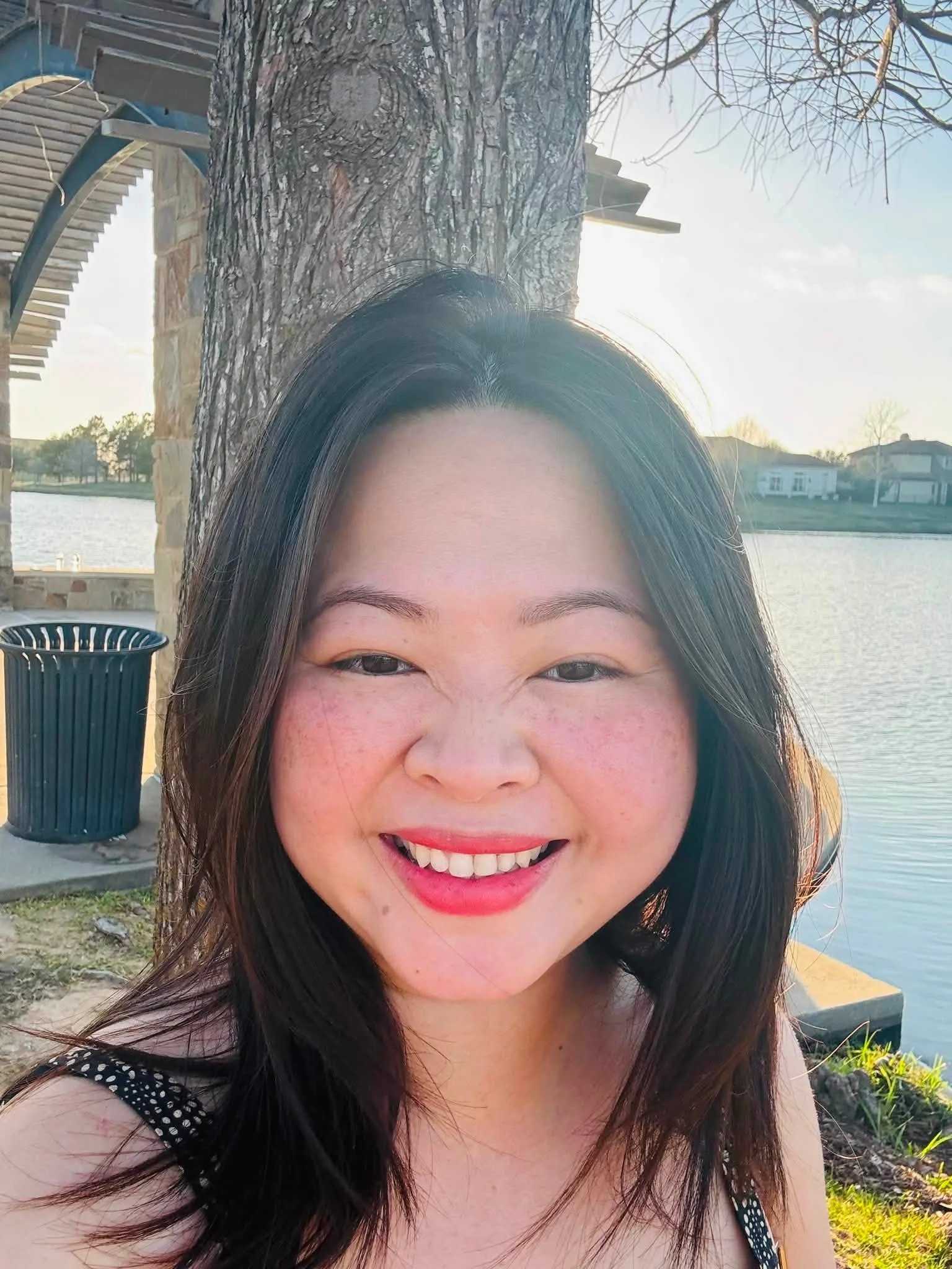 Kylie Dang smiling outdoors by a lake